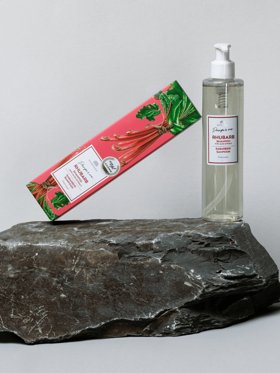 Rabarberschampo med Aloe Vera i klar flaska med pump och rosa förpackning med rhubarb-motiv på stenbakgrund