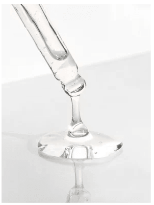 AHA Peeling Concentrate 30 ml - glaspipett som droppar klar genomskinlig serum på vit yta