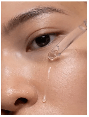Kvinna applicerar genomskinlig gel-textur på kinden, visar AHA Peeling Concentrate som absorberas i huden