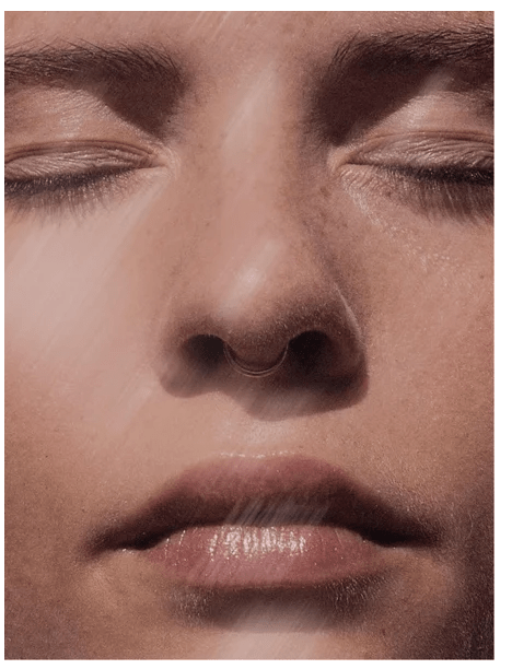 Närbild av kvinna med stängda ögon som visar naturlig hudstruktur och porer, relevant för Acne Spot Care Serum