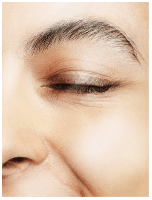 Närbild på kvinnas ansikte med sluten ögon och naturlig makeup som visar mjuk, välvårdad mogen hud