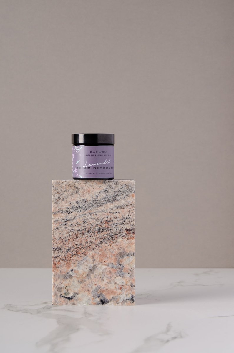 Bonobo lavendel deodorantkräm i lila burk med svart lock, placerad på marmorsockel mot neutral bakgrund