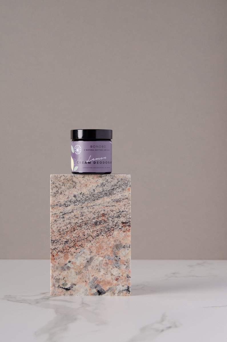 BONOBO deodorantkräm i lila burk med svart lock, placerad på marmorblock mot neutral bakgrund