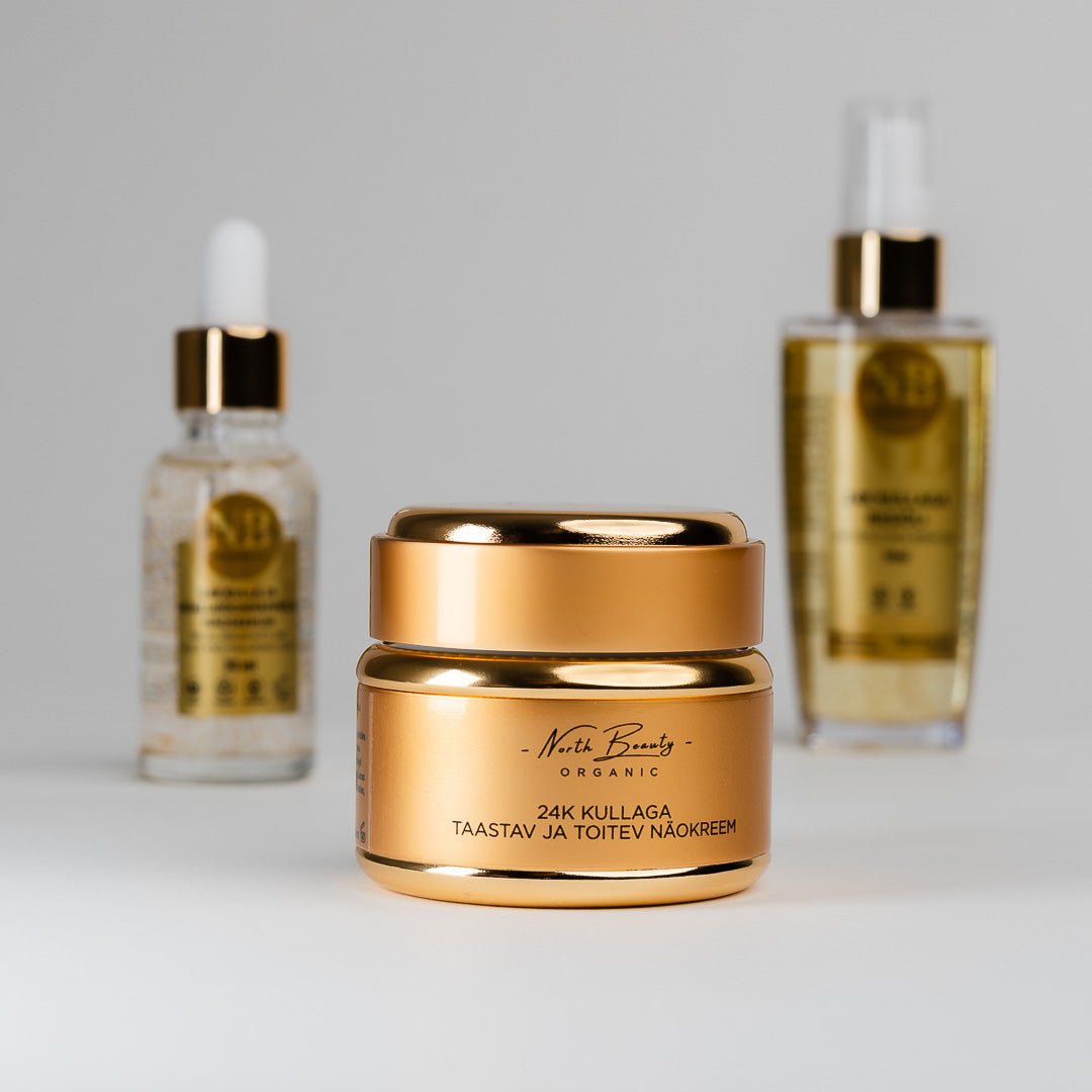 24K Gold Gift Set med guldförgylld ansiktskräm i förgrunden och två serumflaskor med dropper i bakgrunden
