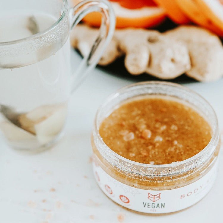 Anti-cellulite Body Scrub Ingefära i genomskinlig burk med gul-orange scrub, synliga korn, vit etikett med röd text