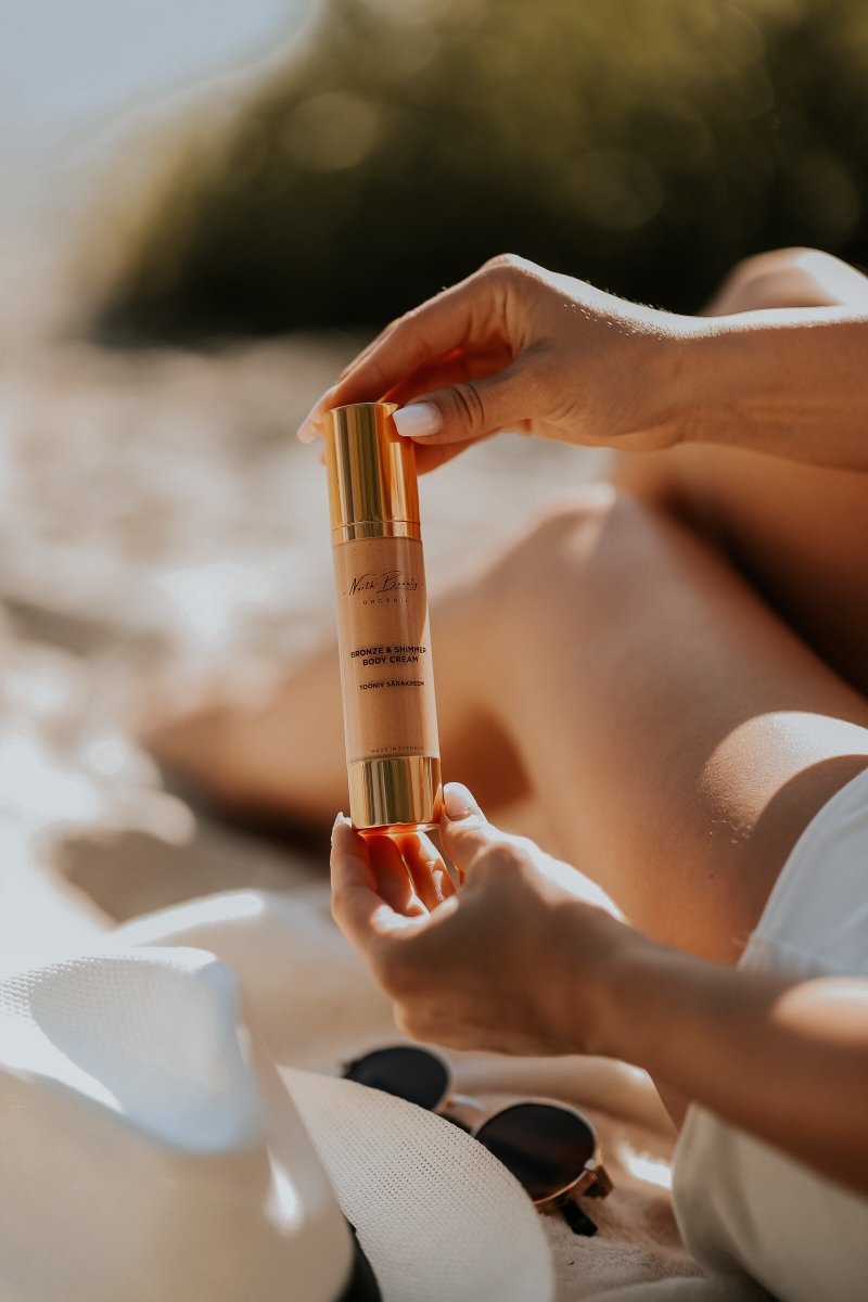 Kvinna håller Tinted Glow Cream med guldigt rör och pump - krämig hudvårdskräm för naturlig lyster
