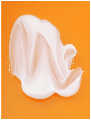 Krämig vit textur av Retinol Alternative Moisturiser mot orange bakgrund, visar produktens mjuka och smidiga konsistens