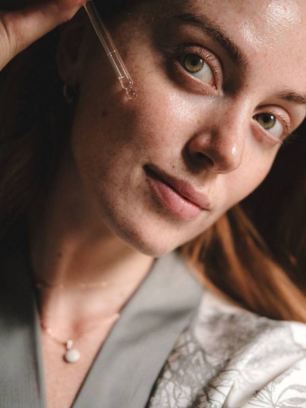 Kvinna applicerar Anti-Aging Bakuchiol Serum med pipett, naturligt retinol-alternativ för mogen hud
