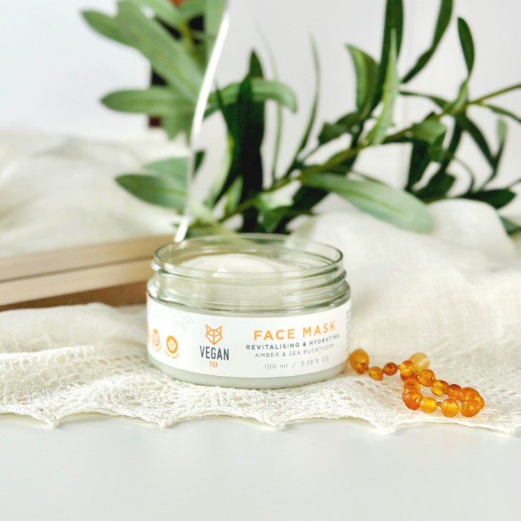 Revitalising & Hydrating Face Mask i glasburk med vit kräm, vegan-märkning och havtornsfrön bredvid gröna växter