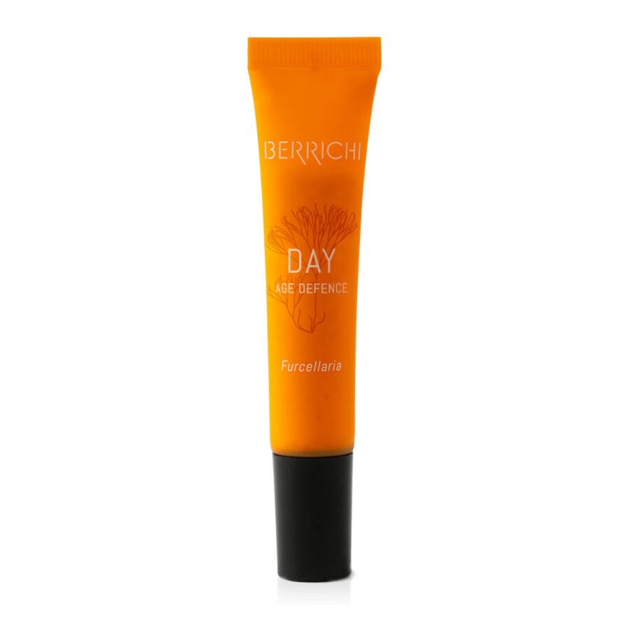 Orange tubenförpackning av Berrichi DAY Age Defence dagkräm med svart lock och elegant design