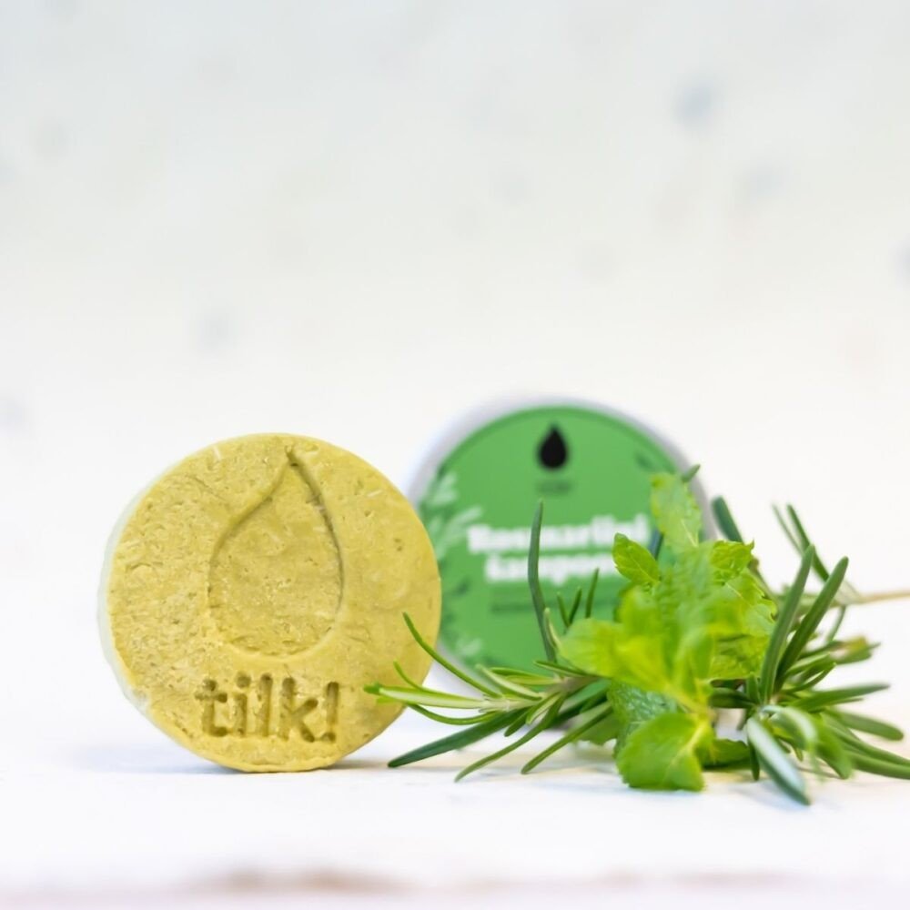 Deep-Cleansing Solid Matcha Shampoo 70g - gul rund tvålkaka med präglat märke bredvid grön glasburk med gröna växter