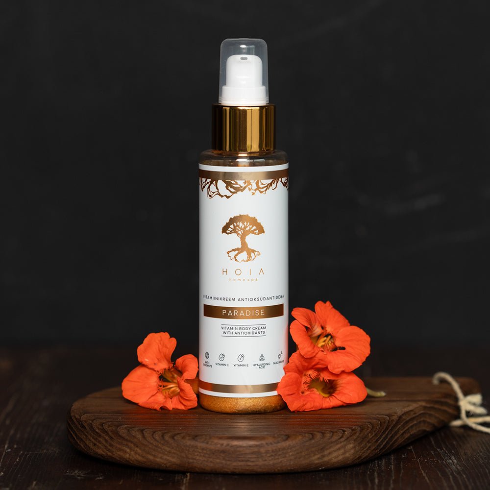 Kroppskräm torr hud vitaminer från HOIA i pumpflaska bland orangea blommor