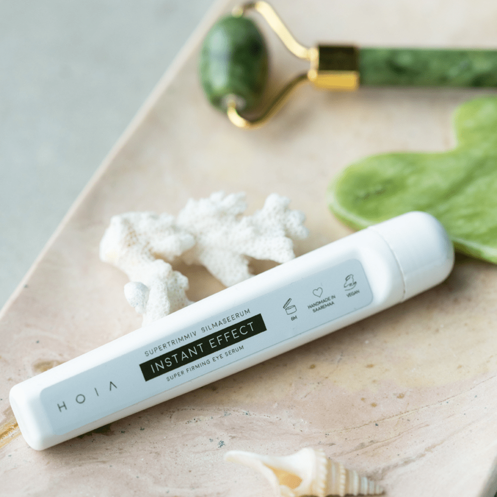 HOIA Superfirming Eye Serum Instant Effect i vit pennapplicator på marmorbricka med jade roller och gröna blad