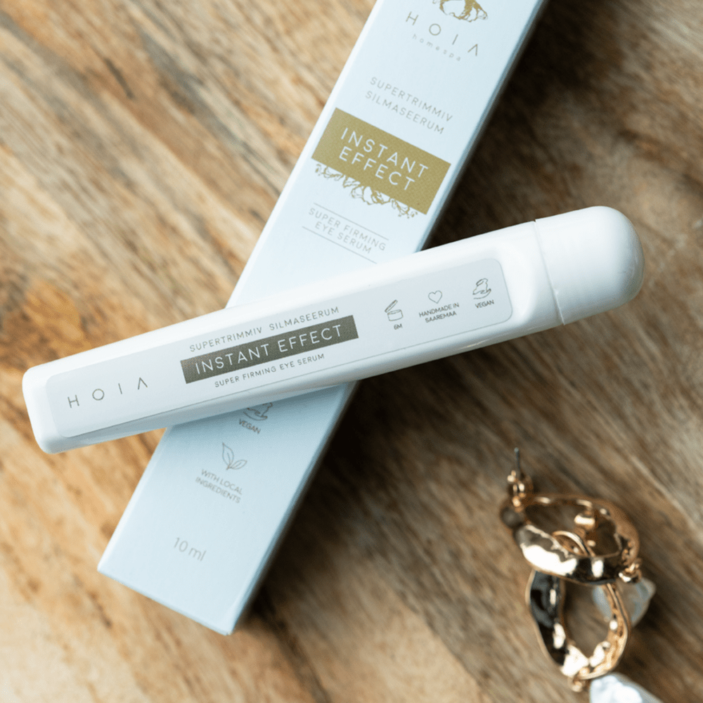 HOIA Superfirming Eye Serum Instant Effect i vit tubförpackning med matchande kartong på träbord
