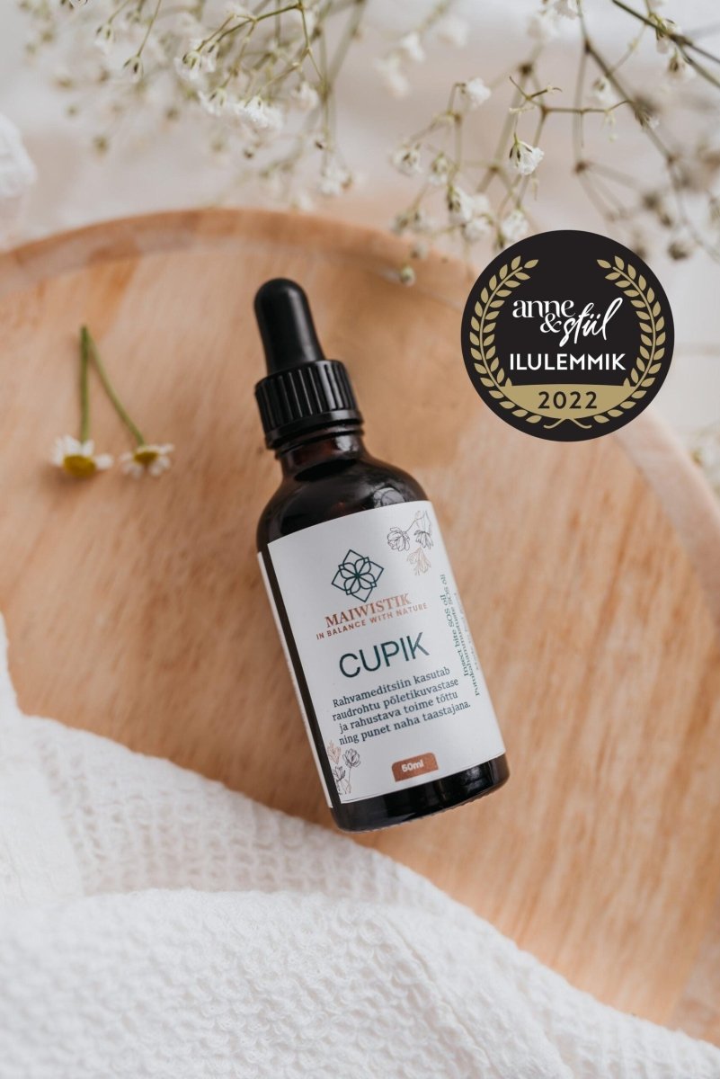 CUPIK hudolja mot rodnad och irritation i brun glasflaska med pipett, 50 ml, på träbricka med torkade blommor