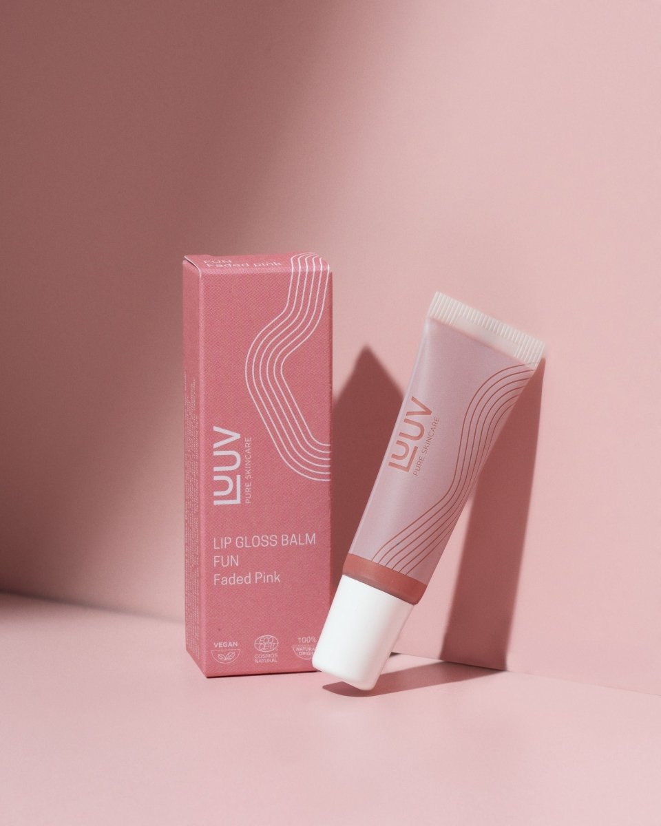 Läppbalsam Fun i rosa tube med matchande förpackning i faded pink nyans på rosa bakgrund