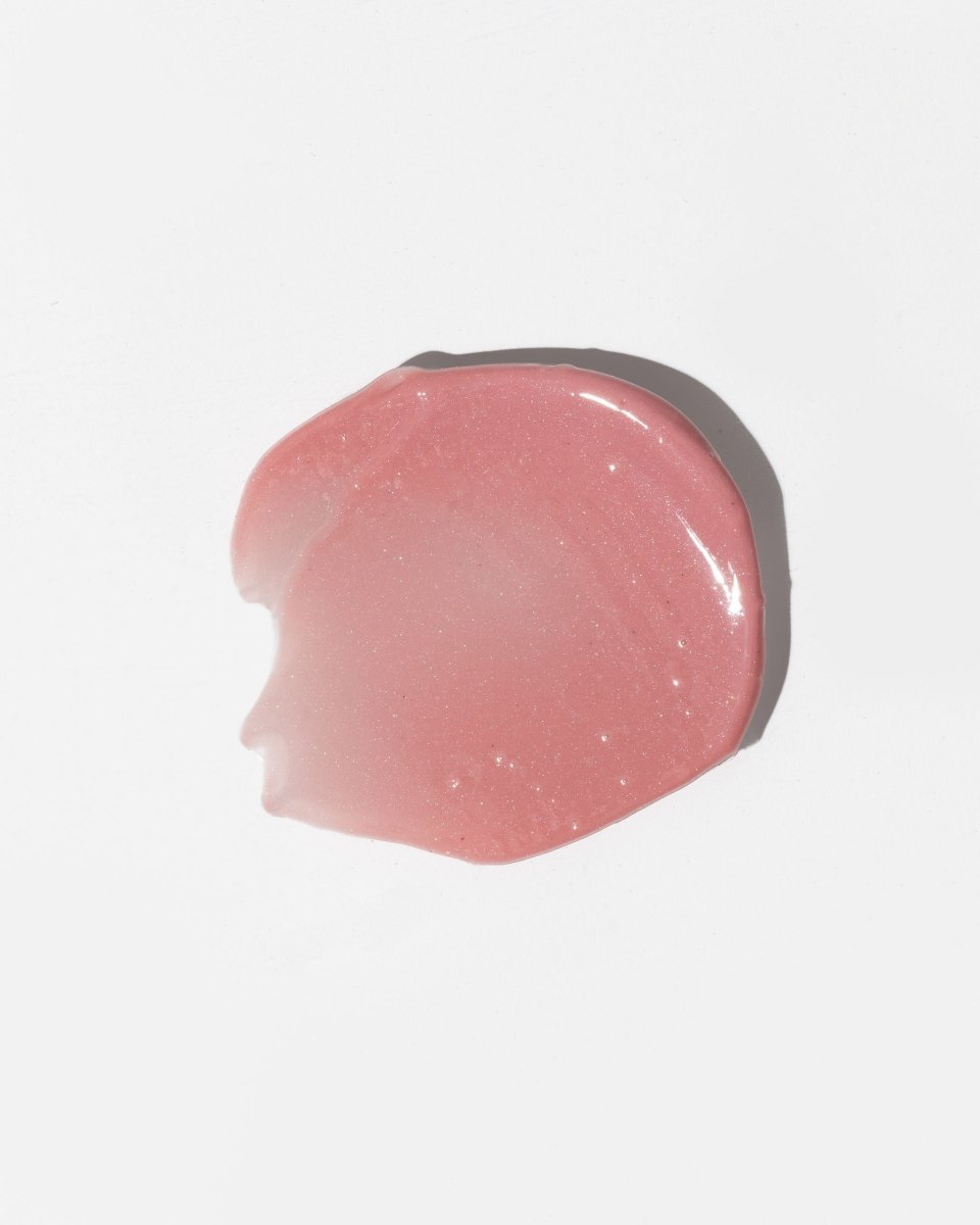 Läppbalsam Sweet - rosa genomskinlig gel med glittriga partiklar i krämig konsistens på vit bakgrund