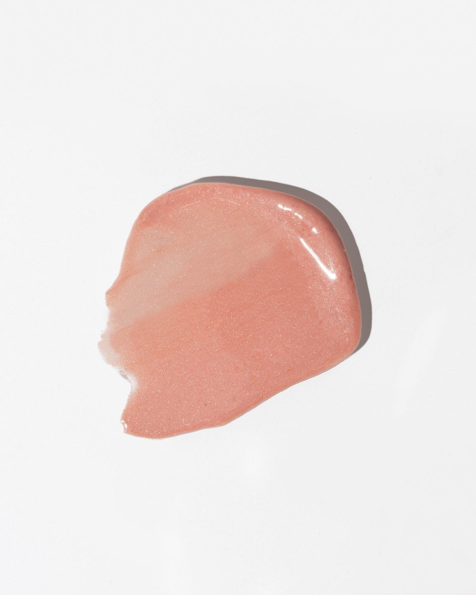 Läppbalsam Young - rosa glansig textur med shimmer utstruken på vit bakgrund, naturlig hudvård