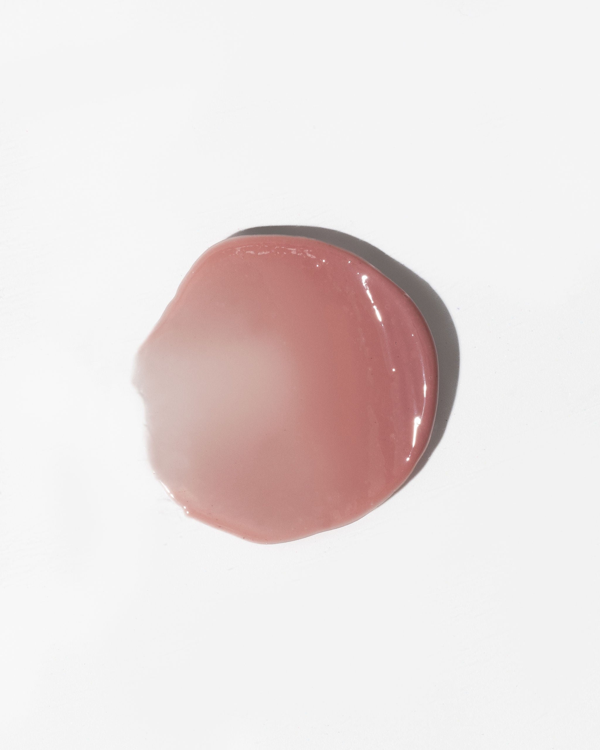 Lip Gloss Balm Secret - rosa genomskinlig läppbalsam med glansig finish i rund klick på vit bakgrund