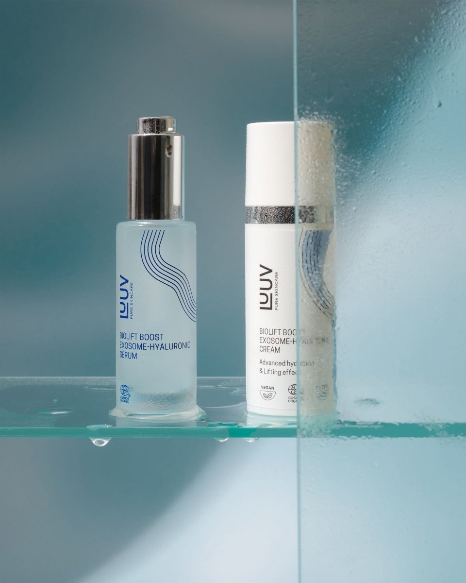 BioLift Exoxome-Hyaluronic serum i frostad glasflaska med silverpump bredvid vit kräm, reflekterat i spegel