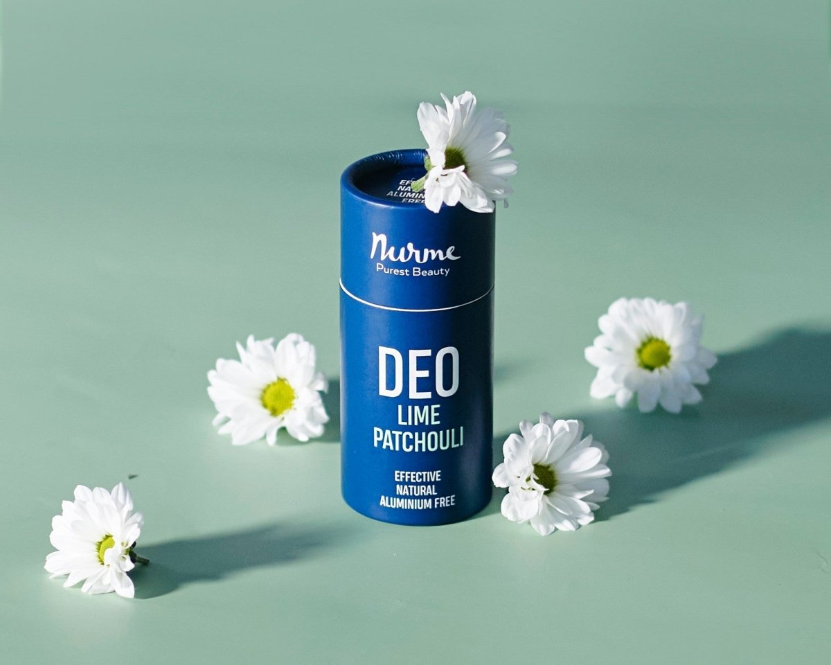 Blå cylinderformad deodorantstick från Nurme med texten DEO Lime Patchouli, omgiven av vita tusenskönor på mintgrön bakgrund