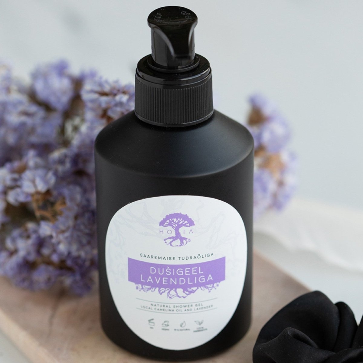 Svart pumpflaska HOIA naturlig duschtvål lavendel bland torkade lila blommor