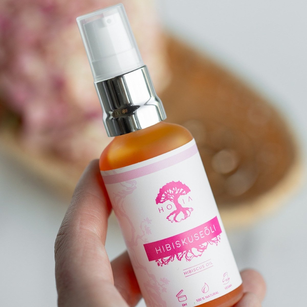 Organic Hibiscus Beauty Oil i 50ml glasflaska med spraypump, orange-amber färgad olja, vit-rosa etikett med hibiskus-motiv