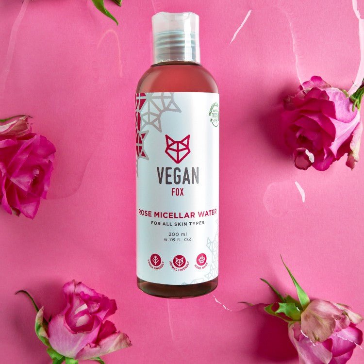 Vegan Fox Rose Micellar Water 200ml flaska med vit etikett och rosa innehåll, omgiven av rosa rosor på rosa bakgrund