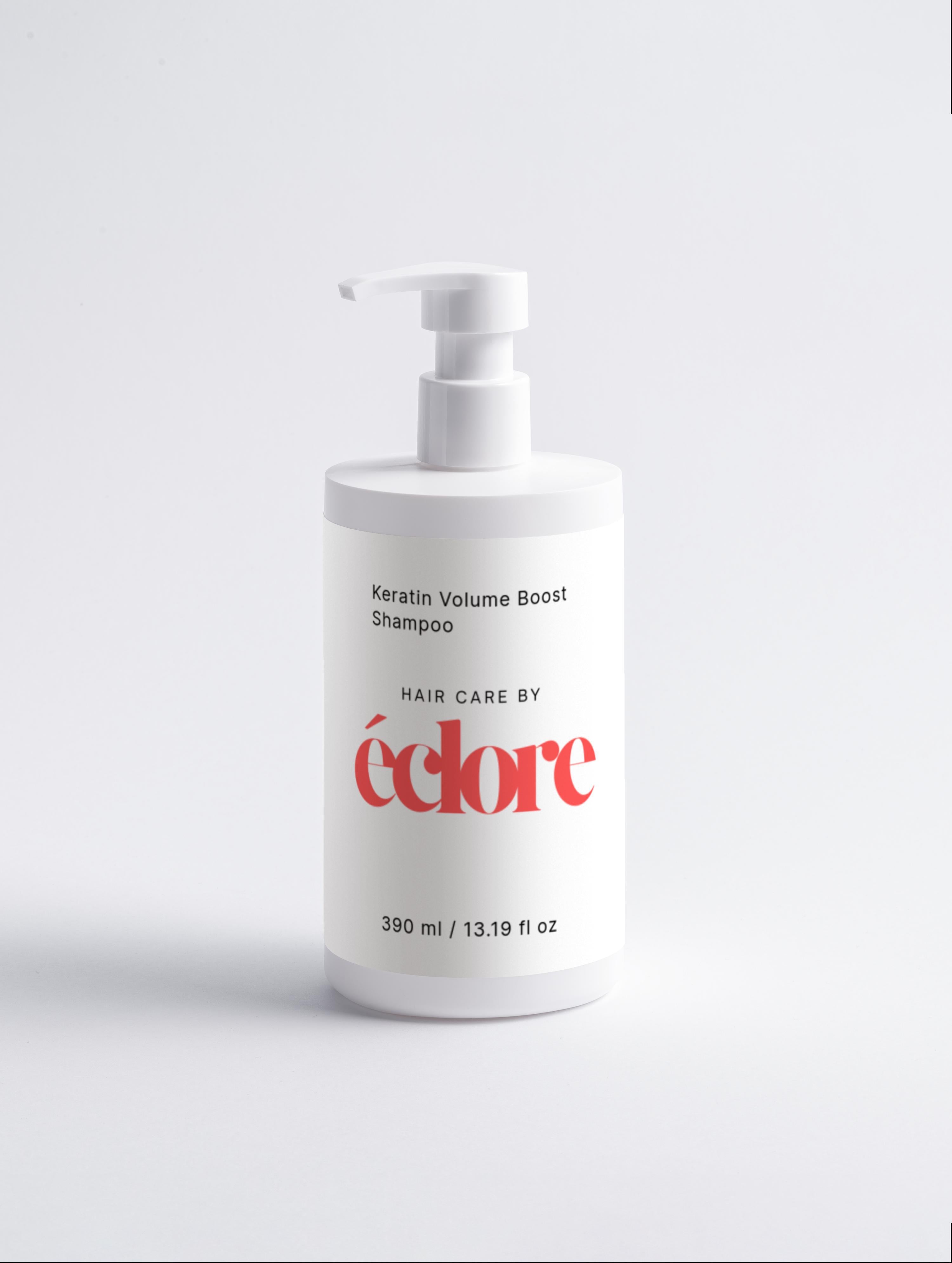 Vit pumpflaska med Keratin Volume Boost Shampoo från éclore, 390 ml, mot ljusgrå bakgrund