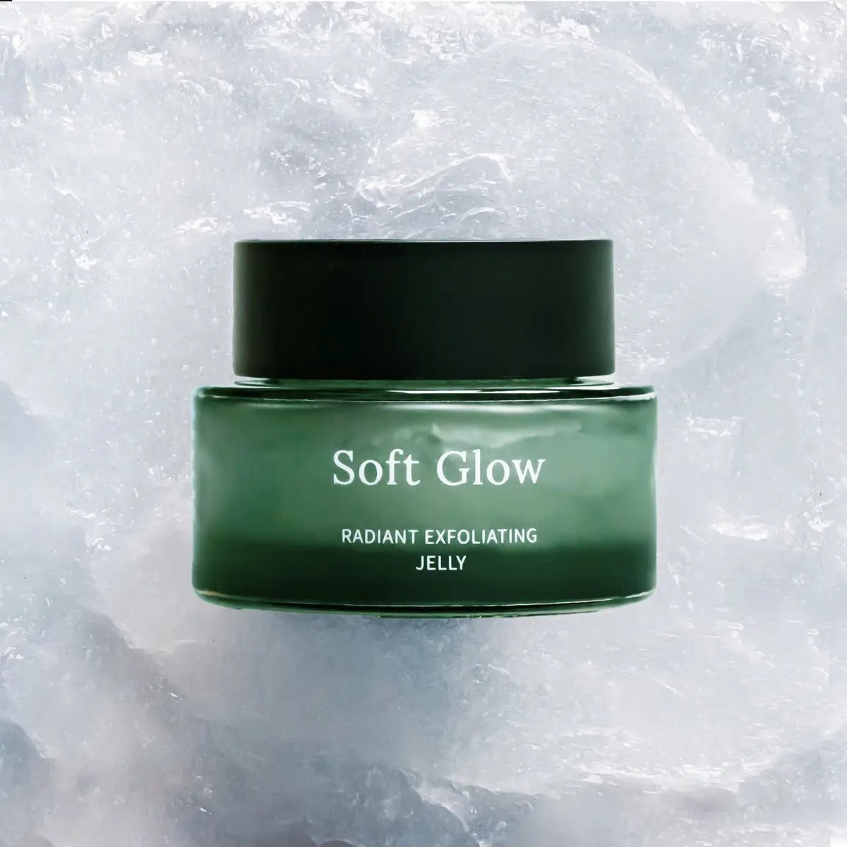 Soft Glow Radiant Exfoliating Jelly i grön glasburk med mörkgrön kork, mild ansiktspeeling på isig bakgrund