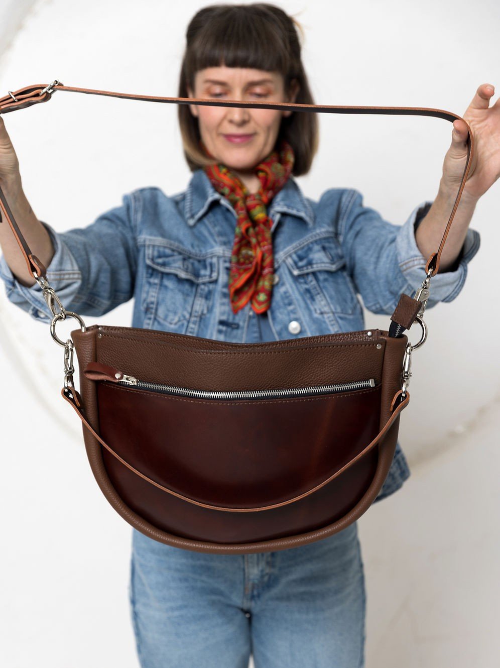 STELLA Leather Handbag i brunt läder med cognacsfärgade remmar, visad av kvinna i jeansjacka och colorful scarf