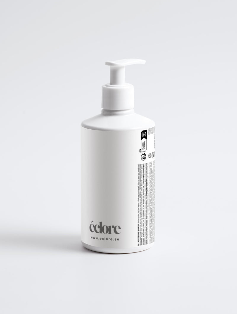 Vit pumpflaska med Moisturising Shampoo från éclore, minimalistisk design med svart text och produktinformation