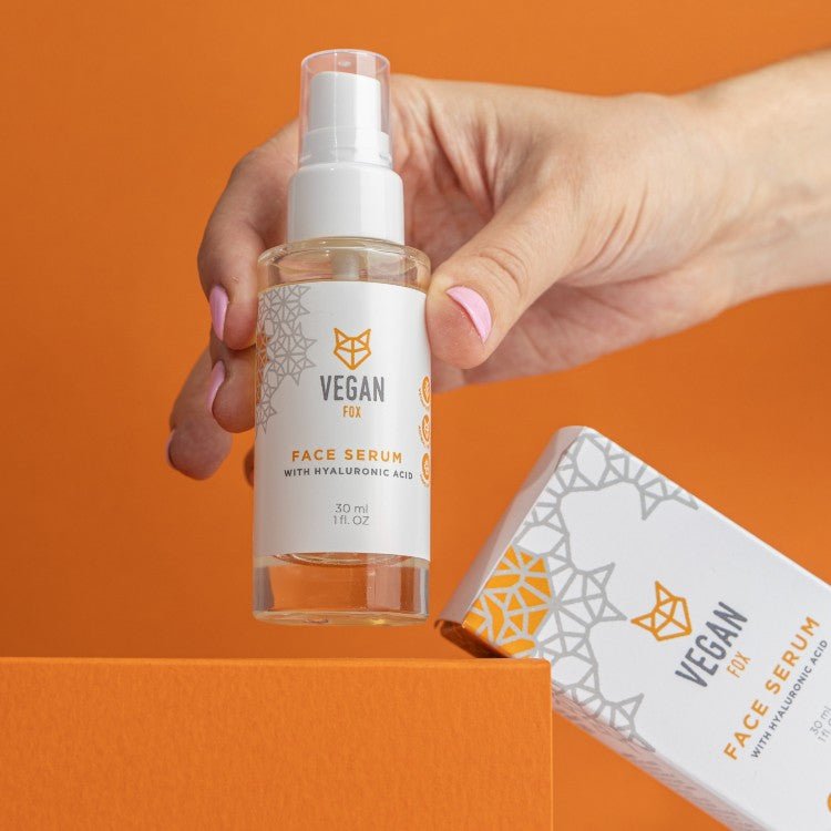 Vegan Fox Face Serum med Hyaluronic Acid i genomskinlig flaska med vit pump, 30ml. Hand med rosa naglar håller produkten.