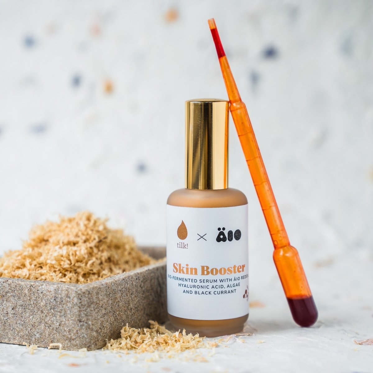 Ansiktsserum naturligt för känslig hud, Skin Booster i glasflaska med pipett bredvid naturmaterial
