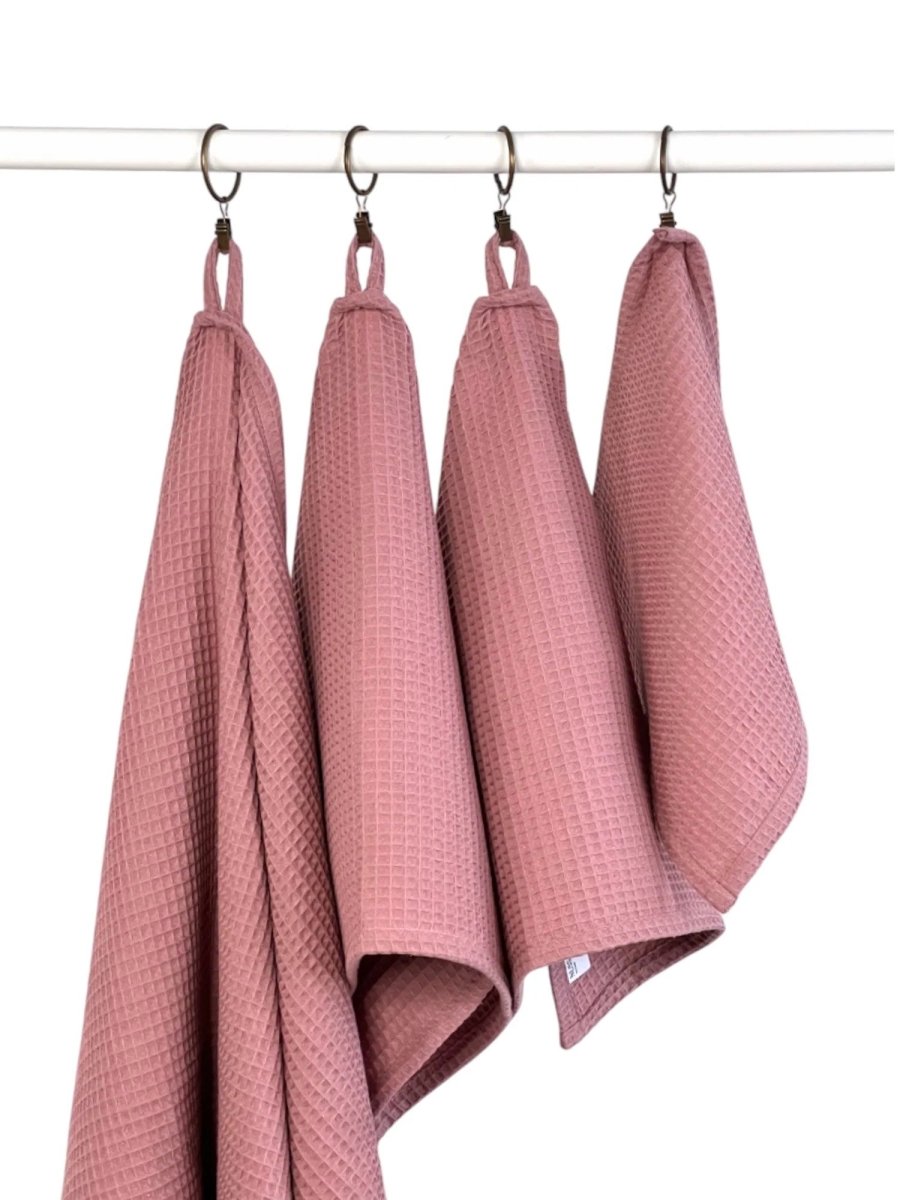 Fyra bomullshanddukar våffla i old pink hängande på stång med hängöglor