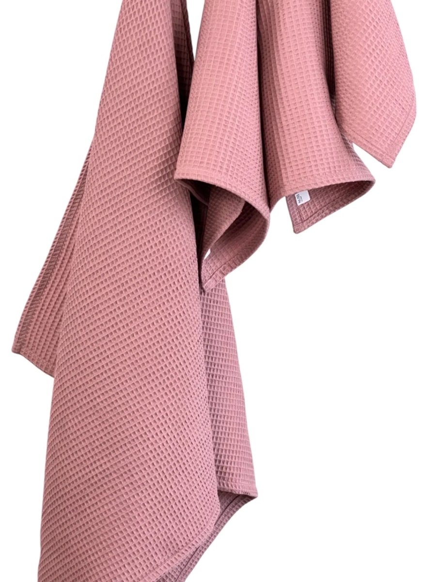 Närbild på bomullshandduk våffla i old pink som hänger och visar den vaffelmönstrade texturen