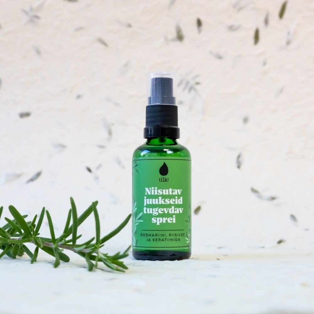 Grön glasflaska med spraypump innehållande fuktgivande och stärkande hårspray, 100 ml, med vit text och rosmaringren