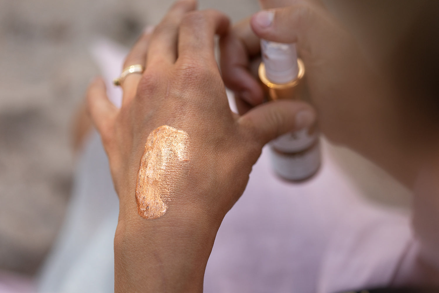 Hand som visar Kroppslotion Body Glam med glittrig, gyllene textur på huden