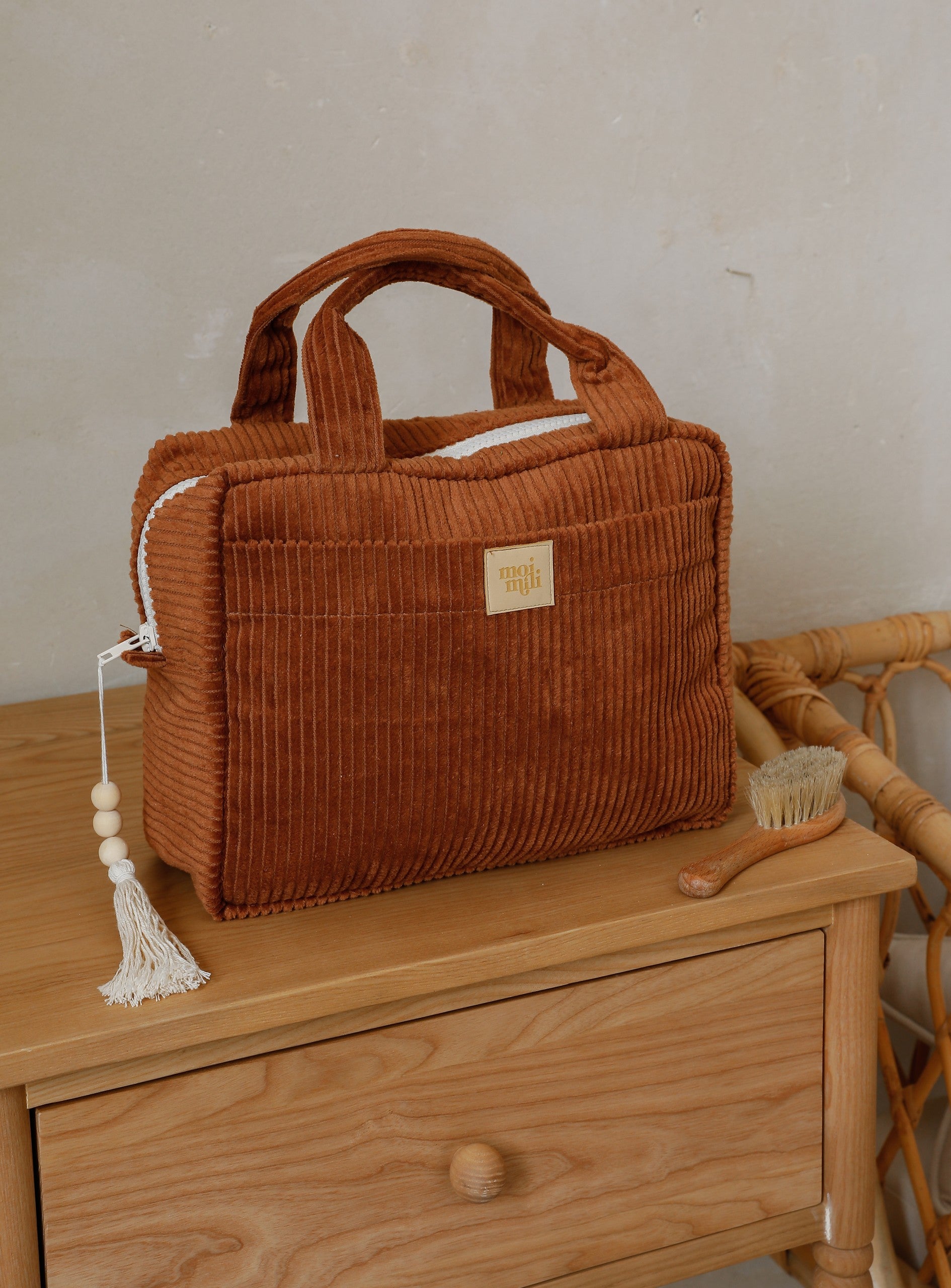 Large Make-Up Bag Caramel i kordbrun manchesterfärg med handtag och tofs, på träbyrå med naturlig finish