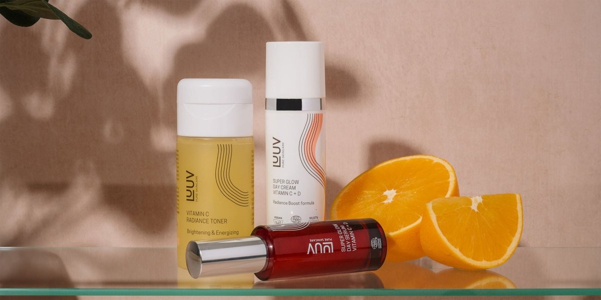 LUUV Vitamin C Radiance Toner bland ansiktsvatten, serum och dagkräm med färska apelsiner i bakgrunden