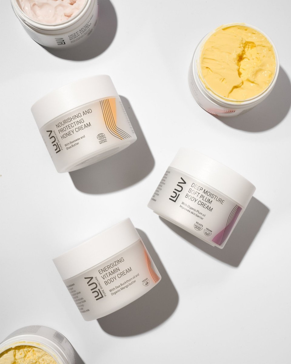 Havtorns och morots Body Cream med mangosmör i vit burk med orange detaljer, gul krämtextur synlig i öppen burk