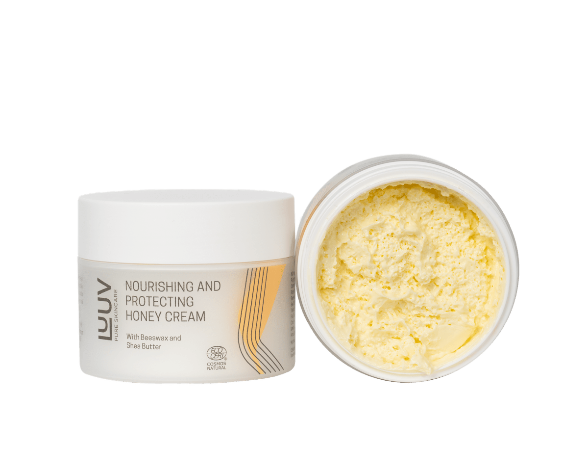 Närande och skyddande honungs Body Cream i vit burk med gul cremig textur synlig i öppnad behållare