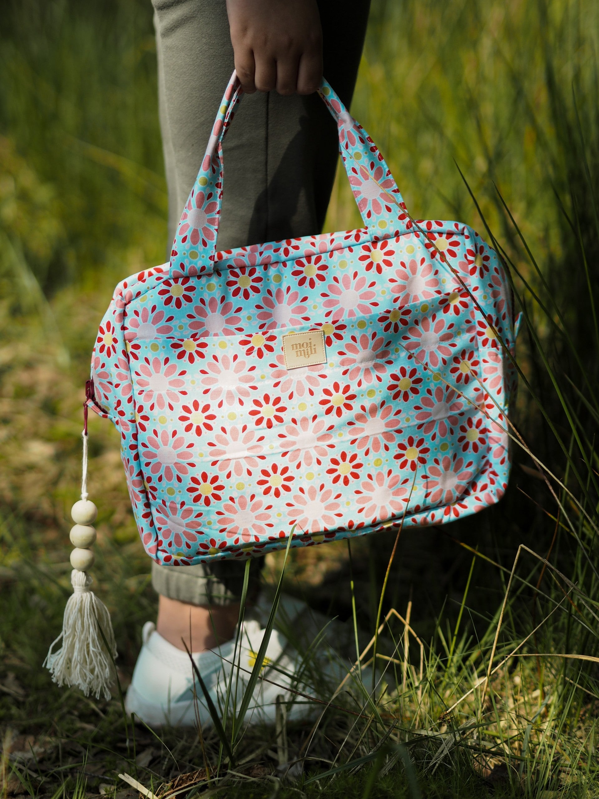 Make-Up Bag Set of 2 Red Flowers - blommig necessär med röda, rosa och turkosa blommor hålls i hand utomhus