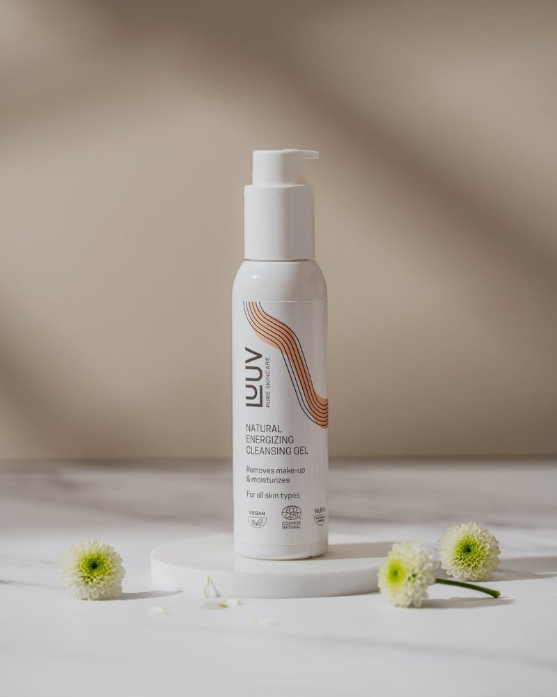 Natural Energizing Cleansing Gel i pumpflaska bland vita blommor på marmorbord
