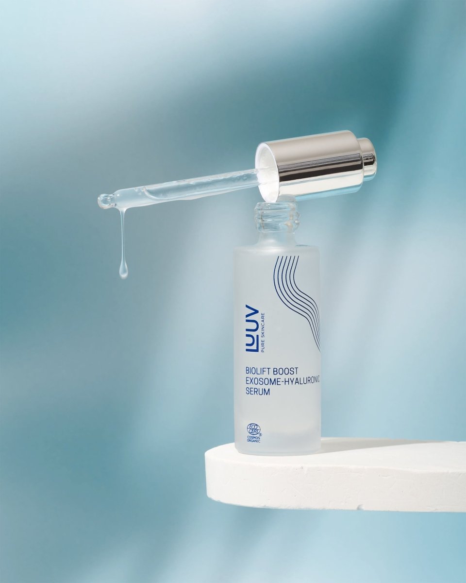 Naturligt anti-age serum i glasflaska med pipett, en droppe serum syns på pipetten