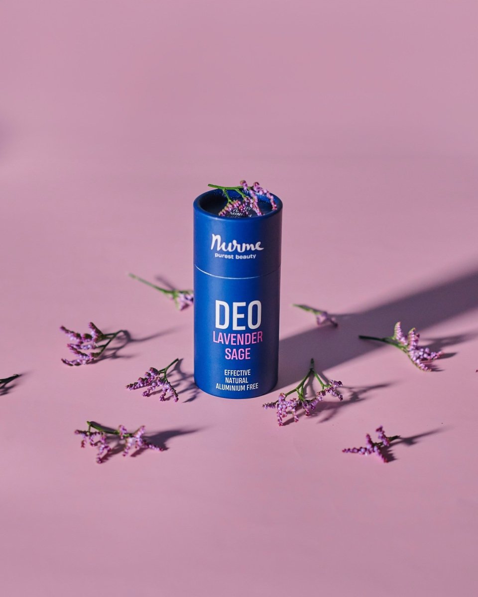 Nurme naturlig deodorant i blå cylinderformad förpackning med lavendel och salvia, omgiven av lila lavendelblommor