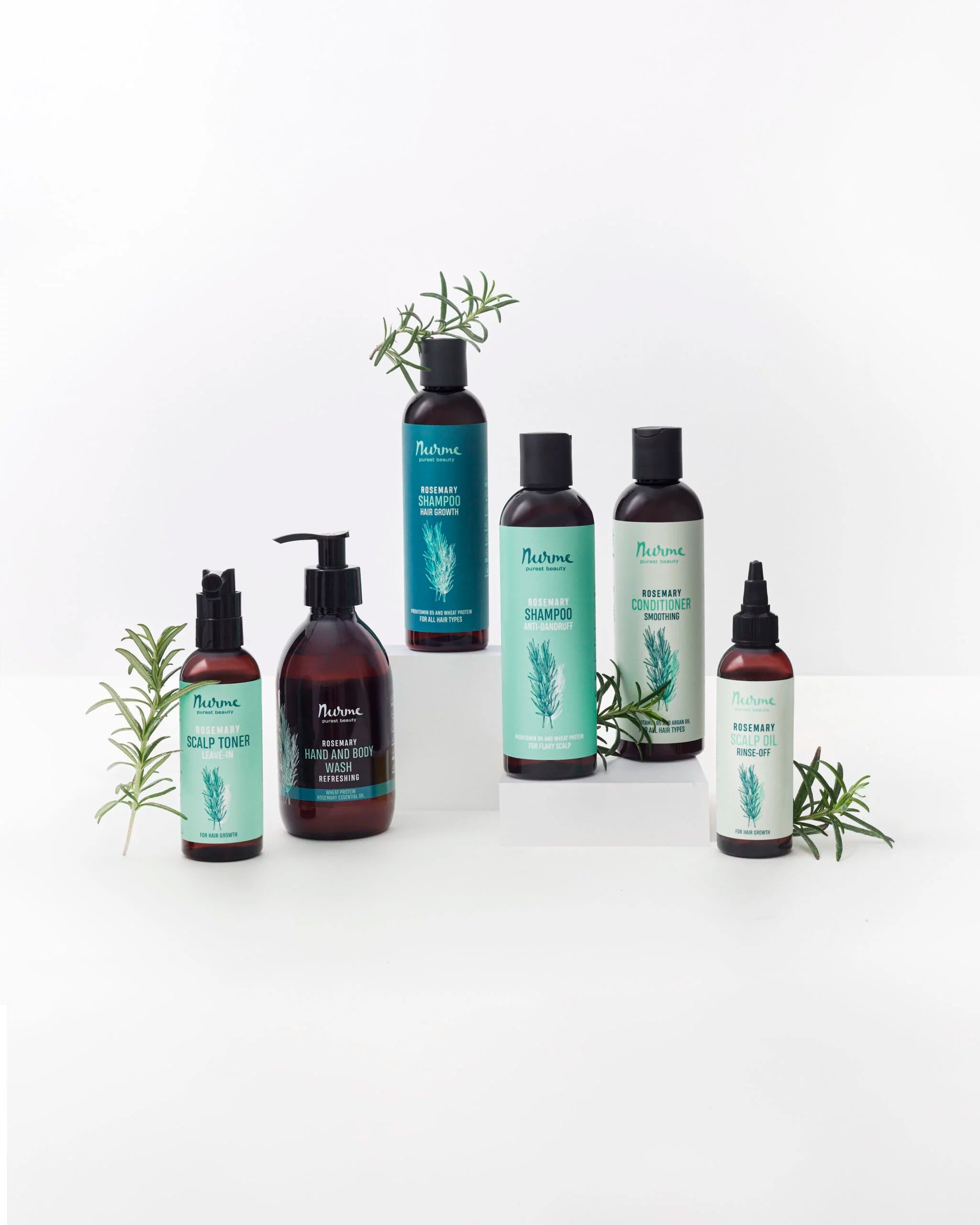 Nurme rosmarinserie med hand- och kroppstvål, schampo, balsam och scalp-olja bland rosmarinkvistar