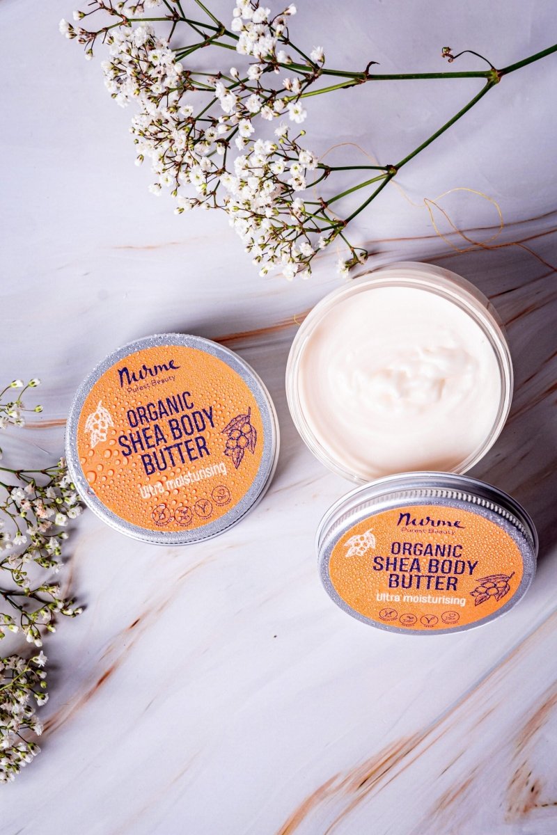 Nurme Travel Size Ultra Moisturising Shea Body Butter 50ml i silvrig burk med orange etikett, öppen burk visar vit krämig textur