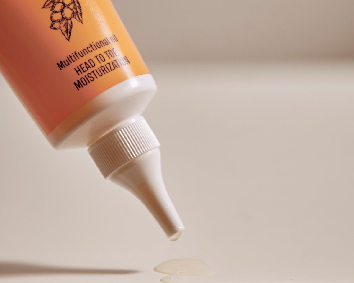 Organic Shea Oil i orange tube med vit twist cap-kork, 100ml naturlig hudolja droppar ut från spetsen