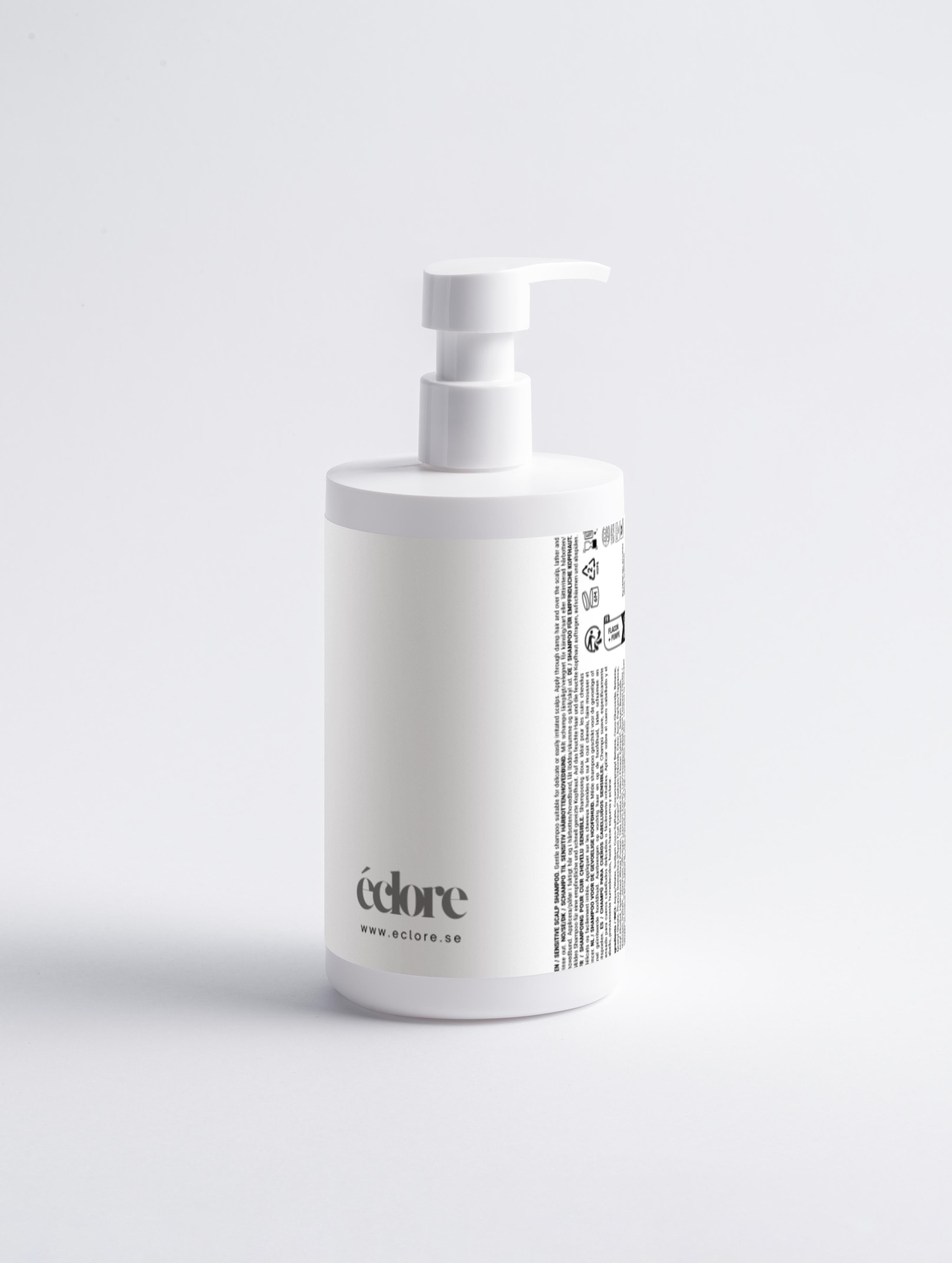 Vit pumpflaska med Sensitive Scalp Shampoo från éclore, cylindrisk form med doserpump och produktinformation på sidan